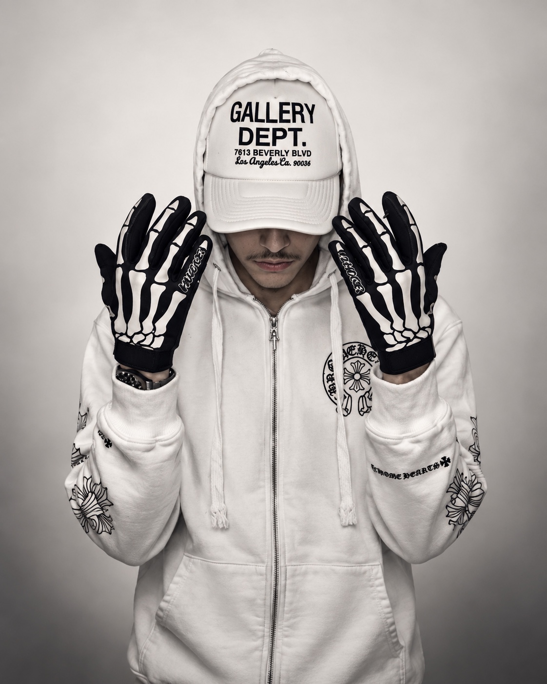Elicit Abandz in a white hoodie and cap with skeleton gloves